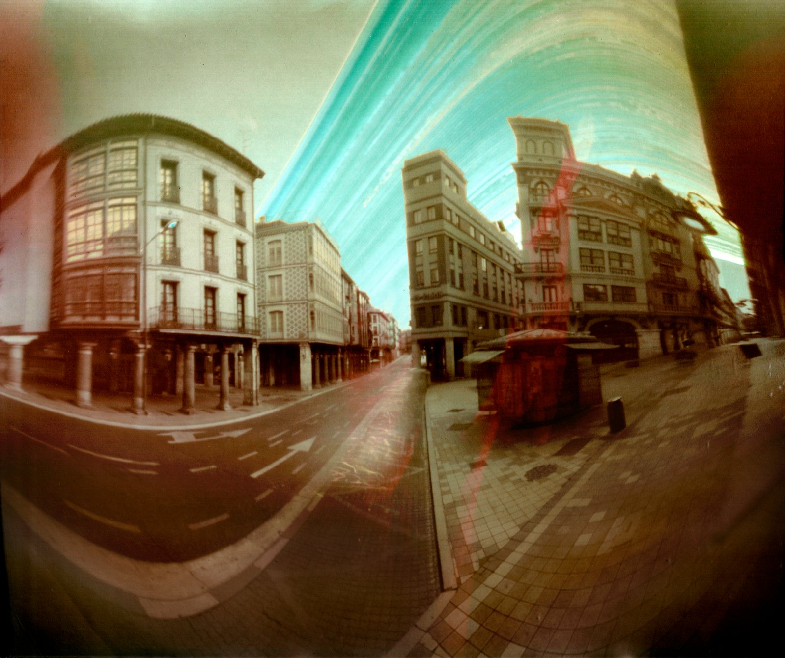 A solargraph — months of the sun's daily arcs burned directly onto photographic paper as glowing curved trails above a landscape