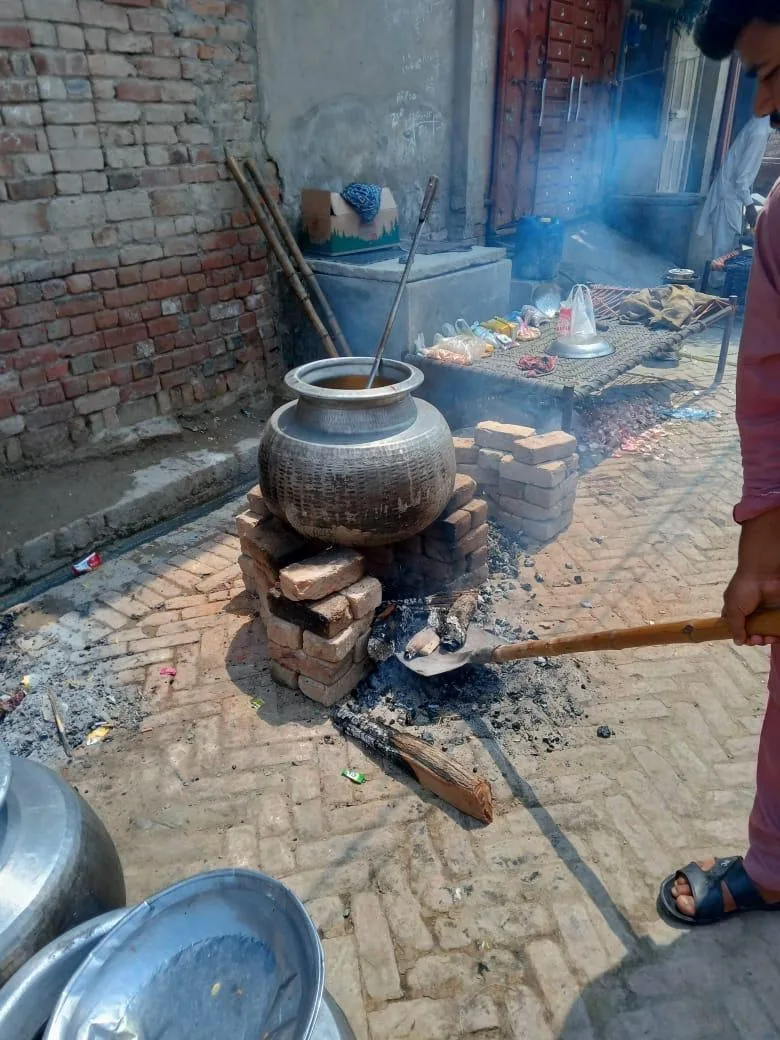 Food cooked in large pots over a fire to feed the congregation